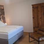 Schlafbereich mit Doppelbett und Holzschrank im Ferienappartement Typ A