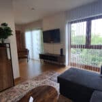 Wohnbereich mit Sofa und großem Fenster im Ferienappartement Typ A