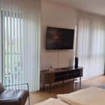 Sessel, Kommode und Fernseher im Ferienappartement Typ A